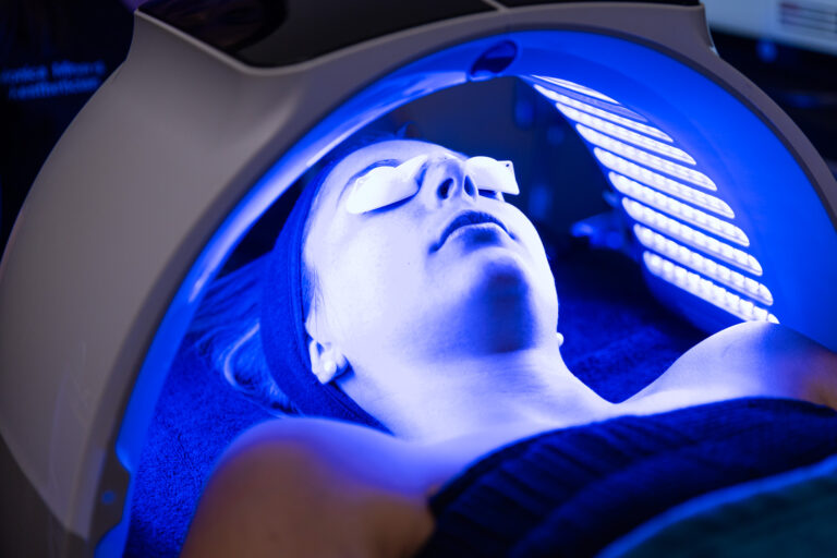 A patient gets light therapy on her face during a HydraFacial, one of our facials in Cedar Park.